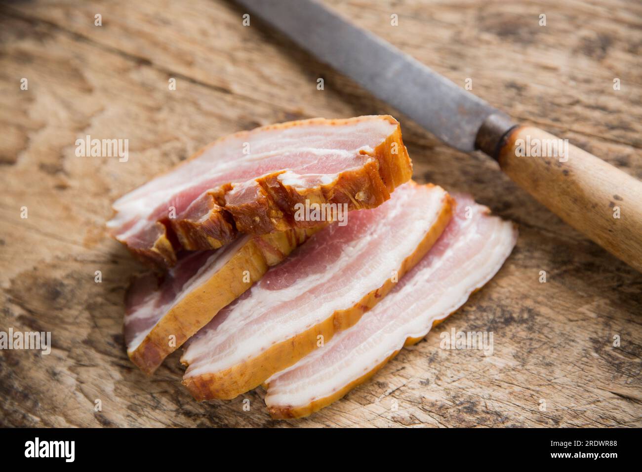 Fette di pancetta cruda affumicata da una delicatessen polacca che sarà inclusa in uno stufato. Inghilterra Regno Unito GB Foto Stock