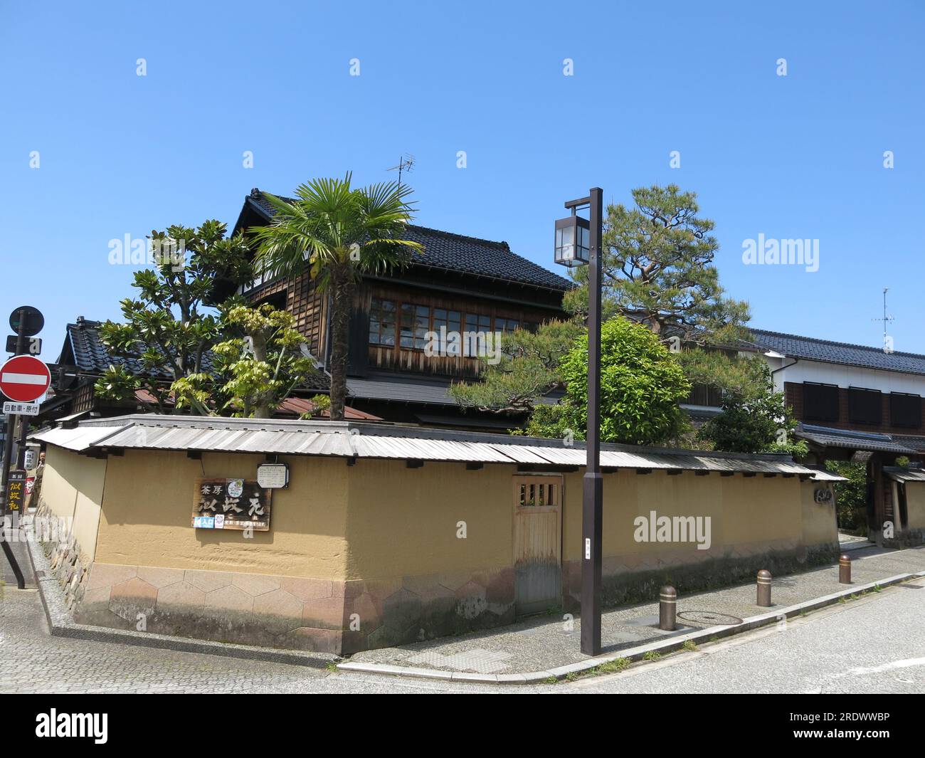 Alte pareti gialle di terra con piccole porte caratterizzano il quartiere di Nagamachi a Kanazawa, un'area storica dove viveva la classe Samurai. Foto Stock