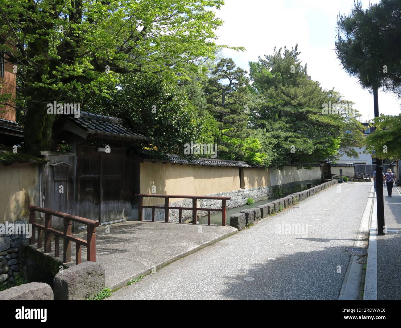 Il distretto di Nagamachi Samurai a Kanazawa è caratterizzato da canali d'acqua lungo le strade tortuose, mura gialle di terra e residenze storiche. Foto Stock