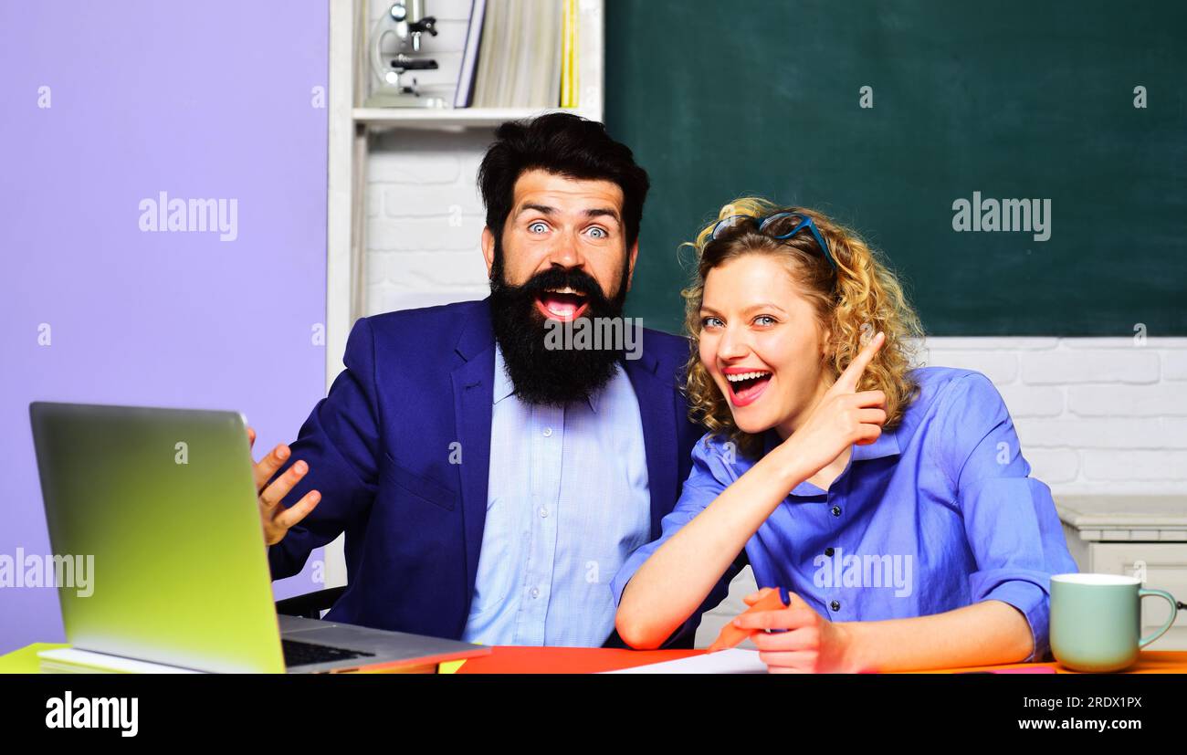 Felice insegnante femminile con studente maschio in classe. Coppia di studenti che studiano al college universitario. Sorridendo insegnanti maschi e femmine sul posto di lavoro Foto Stock