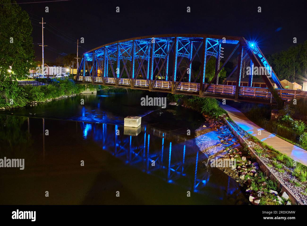 Incredibile immagine laterale del ponte del treno blu al neon di notte sul monte Vernon, Ohio, ponte pedonale e fiume Foto Stock