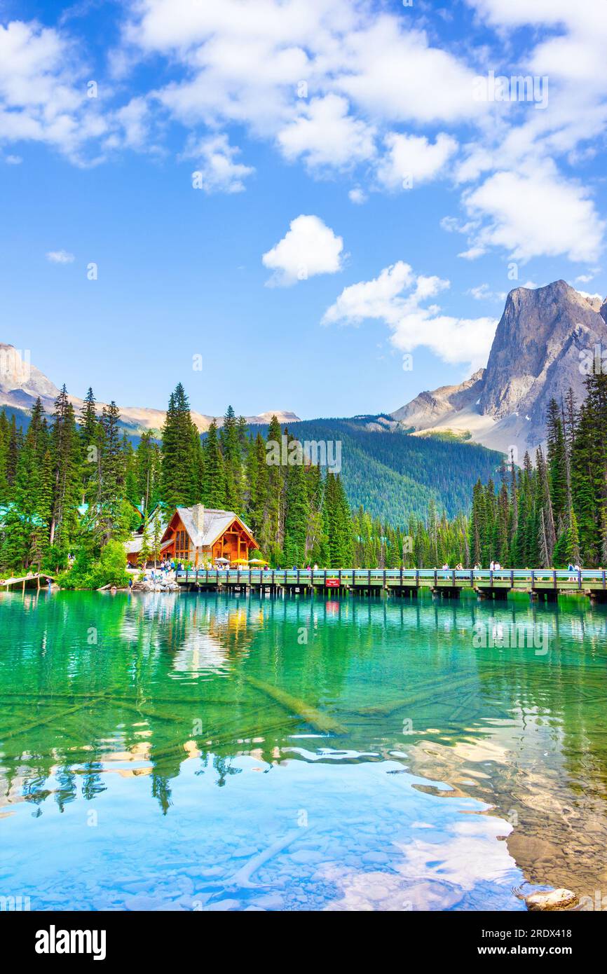 Lago di smeraldo nelle Montagne Rocciose canadesi del Parco Nazionale di Yoho, British Columbia, Canada. Folla non identificabile sul ponte che conduce al Lodge. Orientamento verticale Foto Stock