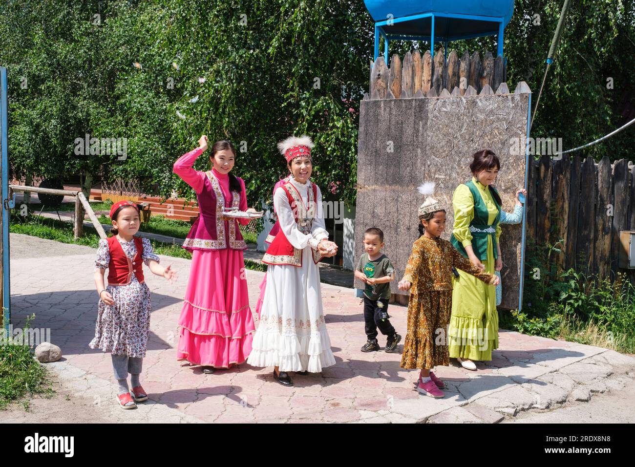 Kazakistan, donne e bambini che danno il benvenuto ai visitatori del villaggio Huns Ethno. Foto Stock