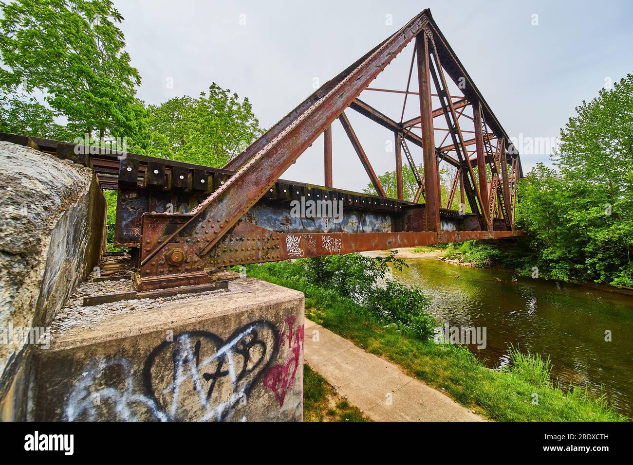 Vista laterale del ponte ferroviario arrugginito in ferro con il sentiero Heart of Ohio Trail e il fiume Kokosing Foto Stock