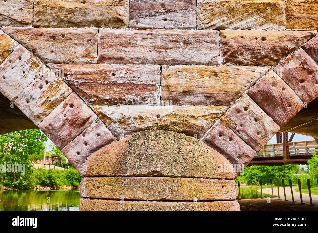 Splendido ponte in pietra con archi geometrici parziali che si avvicinano ai rustici colori bianco e oro Foto Stock