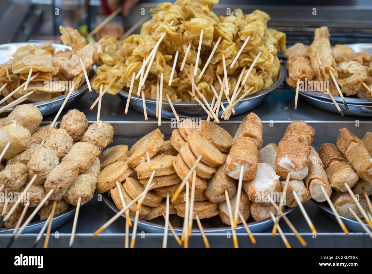 Cibo di strada asiatico, lok, torte di carne e pesce sugli spiedini. Foto Stock