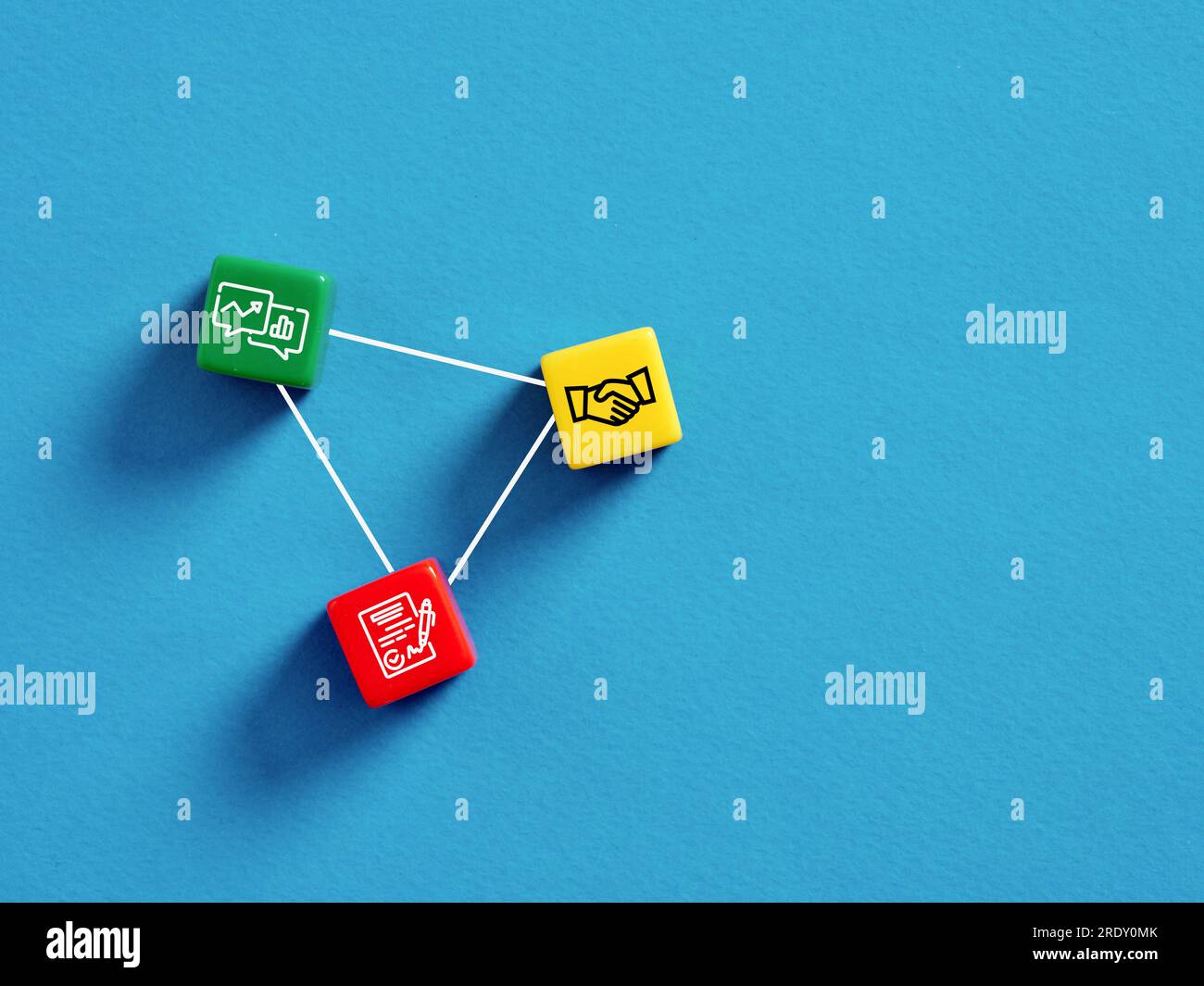 Firmare un contratto commerciale per la crescita e la redditività. Accordo commerciale e partnership di successo. Cubi colorati con simboli delle trattative commerciali in blu Foto Stock