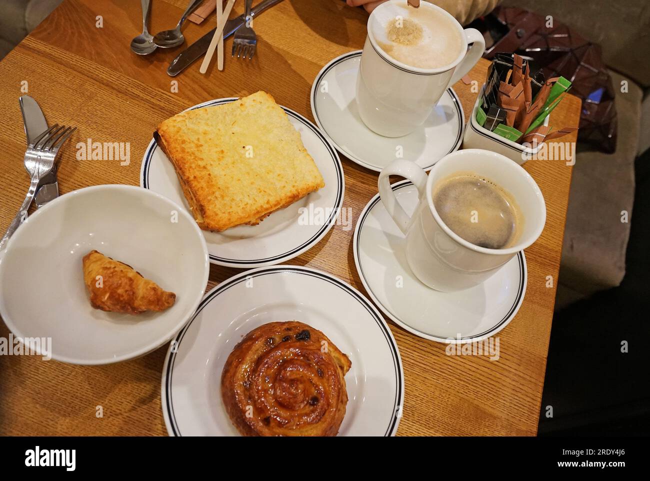 Caffè americano e cappuccino caldo nero servito con croque monsieur, mini croissant e panino danese Foto Stock