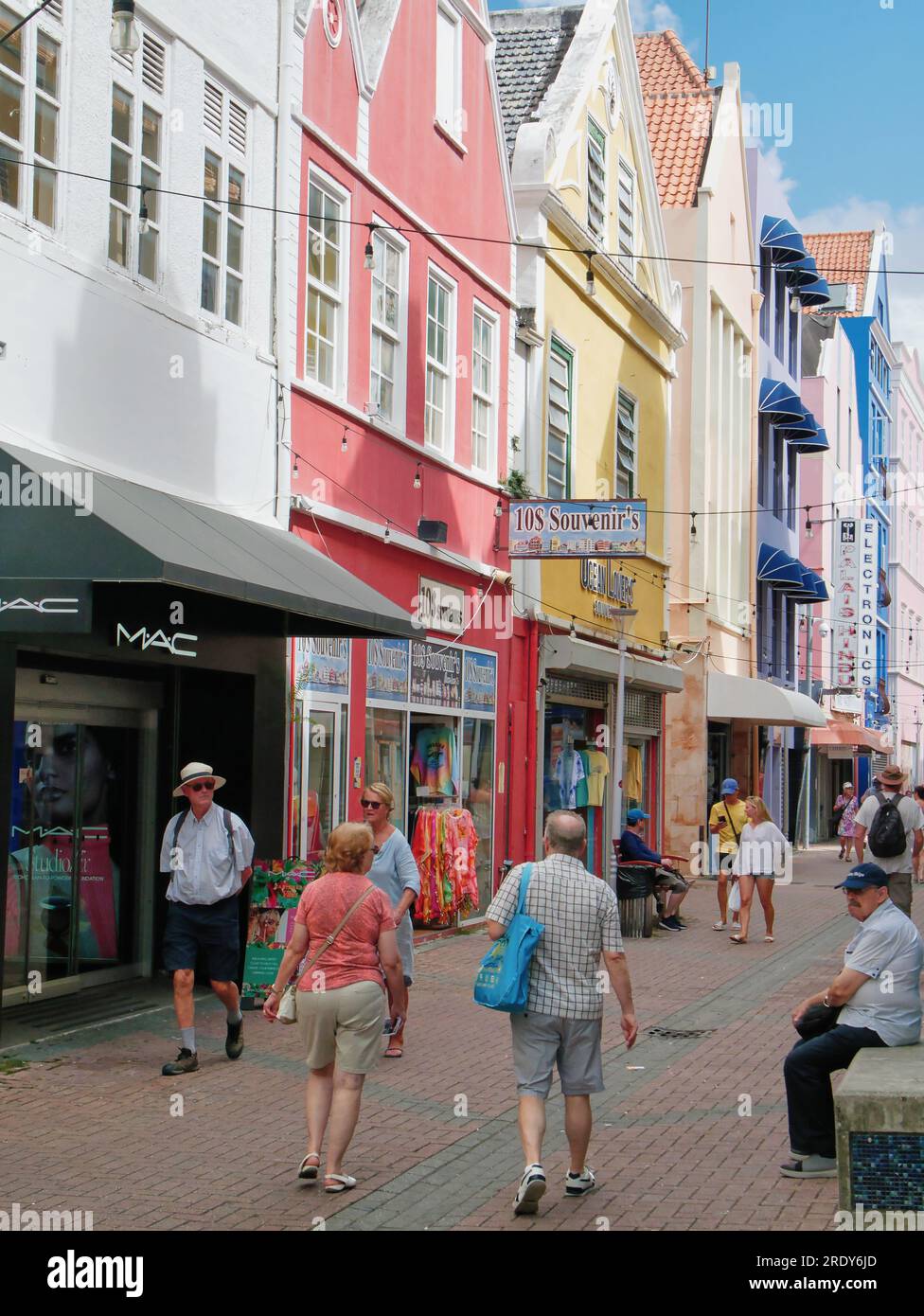 I turisti camminano lungo Heerenstraat, una vecchia strada tradizionale che guarda i negozi di Willemstad, Curacao, Antille olandesi Foto Stock