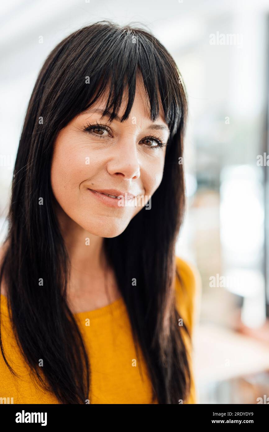Donna matura sorridente con le battute dei capelli Foto Stock