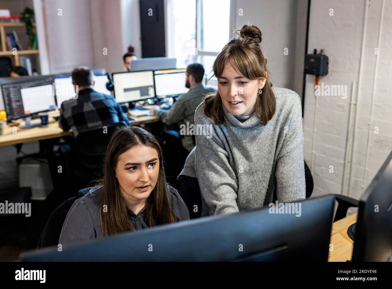 Donna d'affari che parla al computer con un collega in ufficio Foto Stock