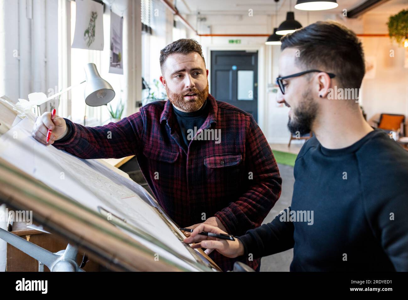 Architetto che spiega e discute con il collega su un progetto Foto Stock