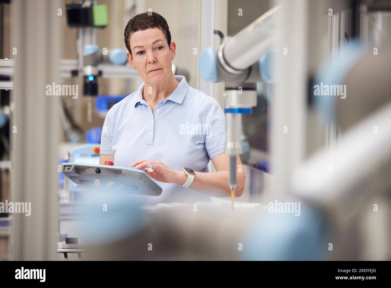 Un tecnico maturo che esegue il collaudo di una parte della macchina utilizzando attrezzature industriali Foto Stock