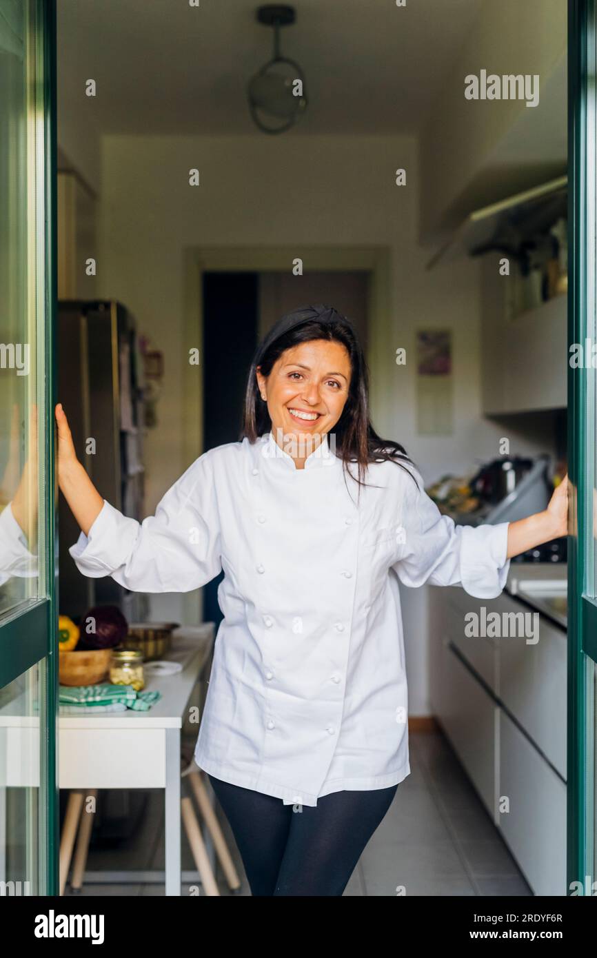 Felice chef che si appoggia all'ingresso Foto Stock