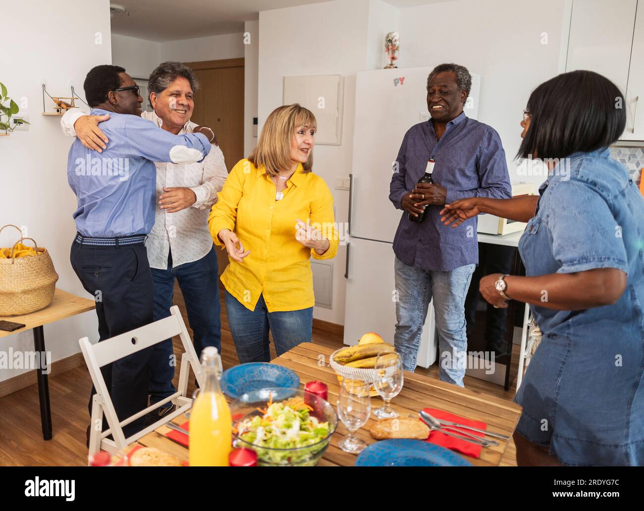 Amici anziani multiculturali che si salutano a casa Foto Stock