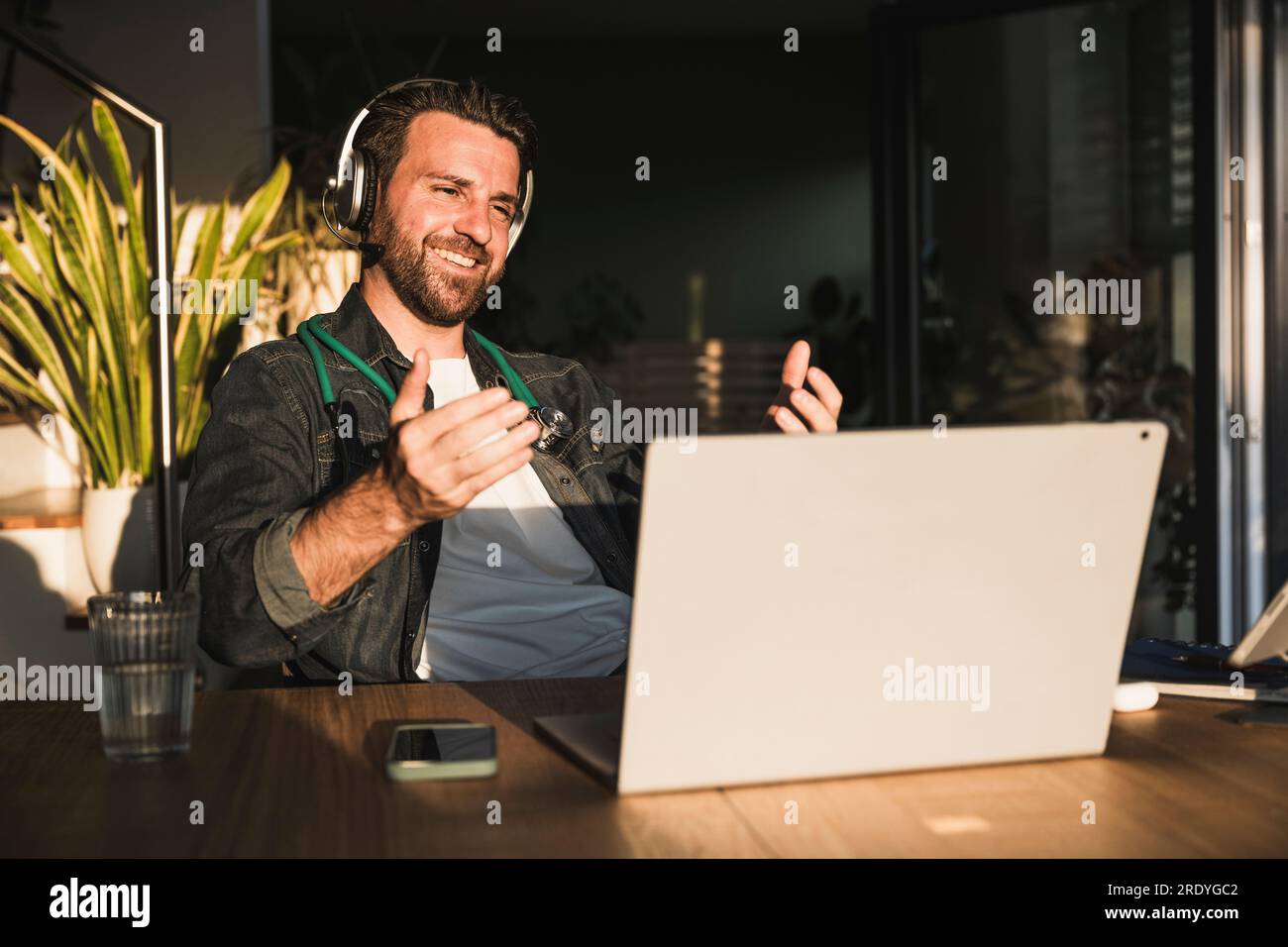 Un medico felice che ti dà consigli tramite videochiamata su un computer portatile Foto Stock