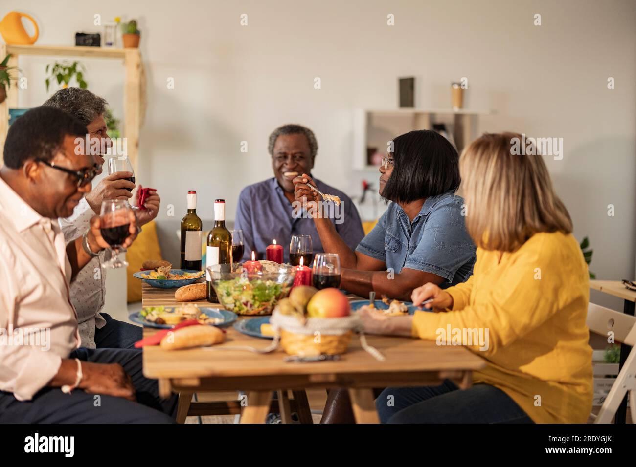 Felici amici multiculturali anziani che mangiano a cena Foto Stock