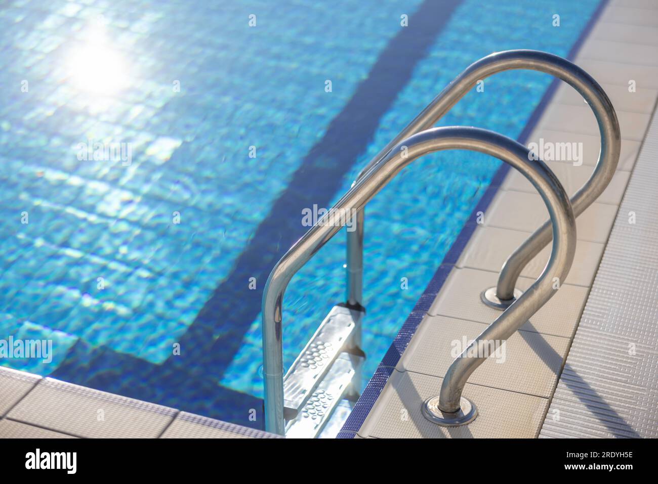 Moderna piscina blu con gradini in acciaio inossidabile. Foto Stock