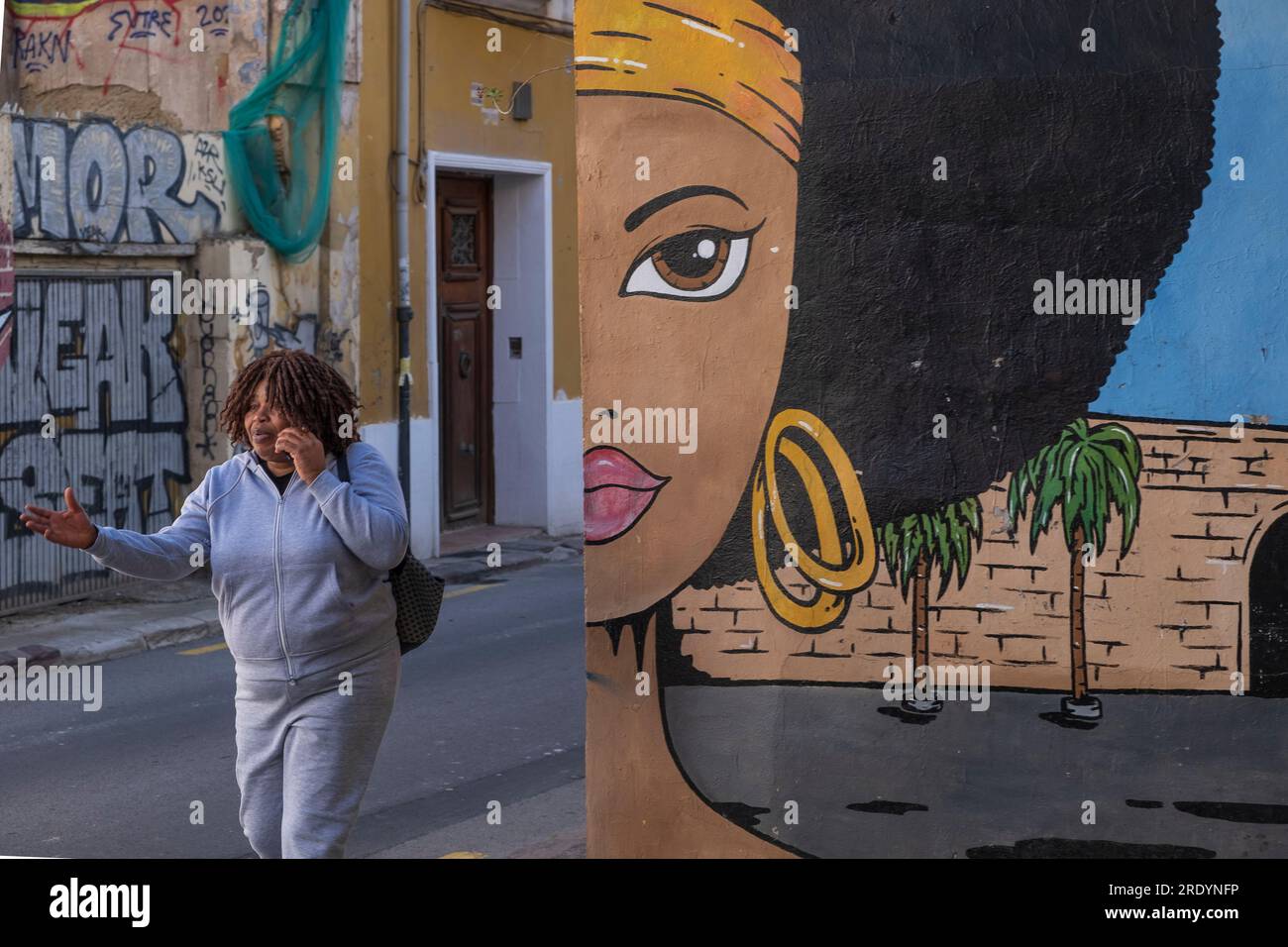 Strassenszene mit einer Frau vor Street Art in der Altstadt von Valencia *** Street Art nel centro storico di Valencia Foto Stock