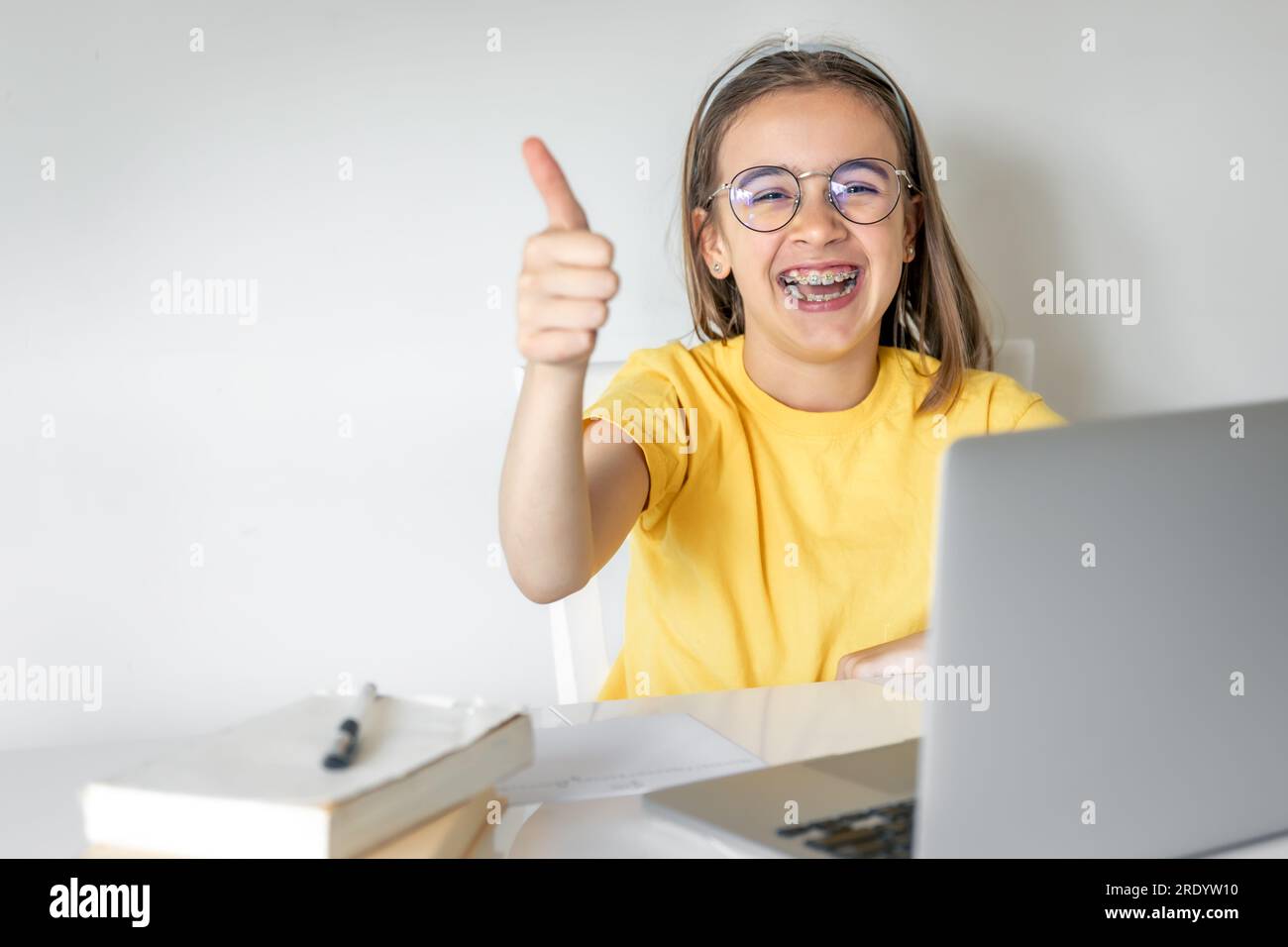Carina studentessa con un portatile che studia a casa, impara online. Foto Stock