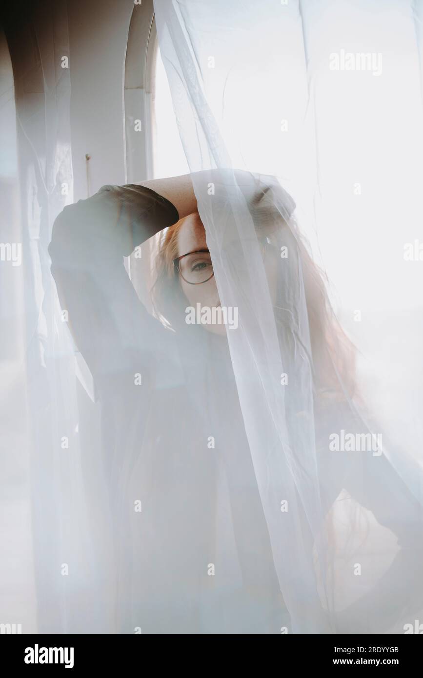 Donna rossa davanti a Window Foto Stock