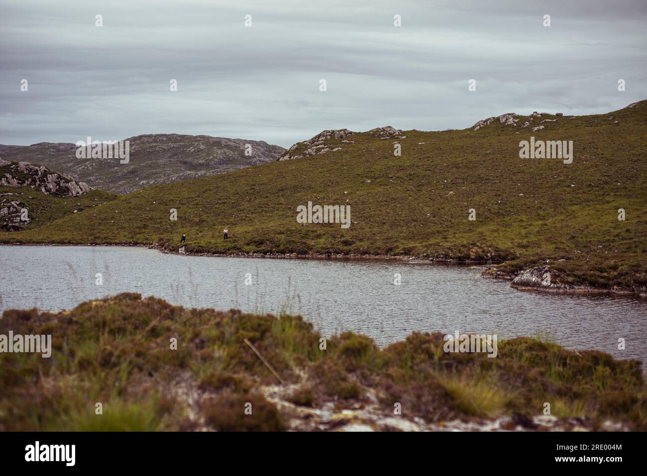 Una coppia in pensione pesca la trota in Scottish loch Foto Stock