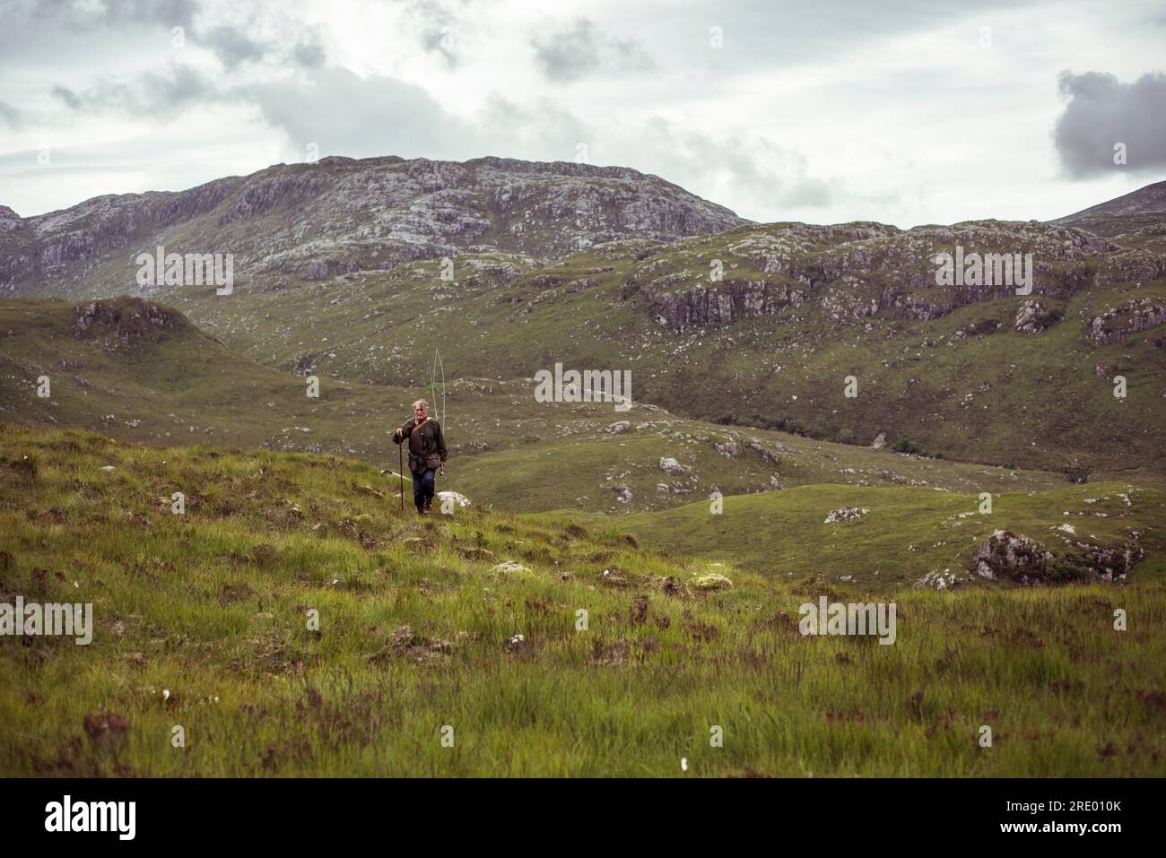 l'uomo in pensione cammina lungo montagne remote durante una battuta di pesca Foto Stock