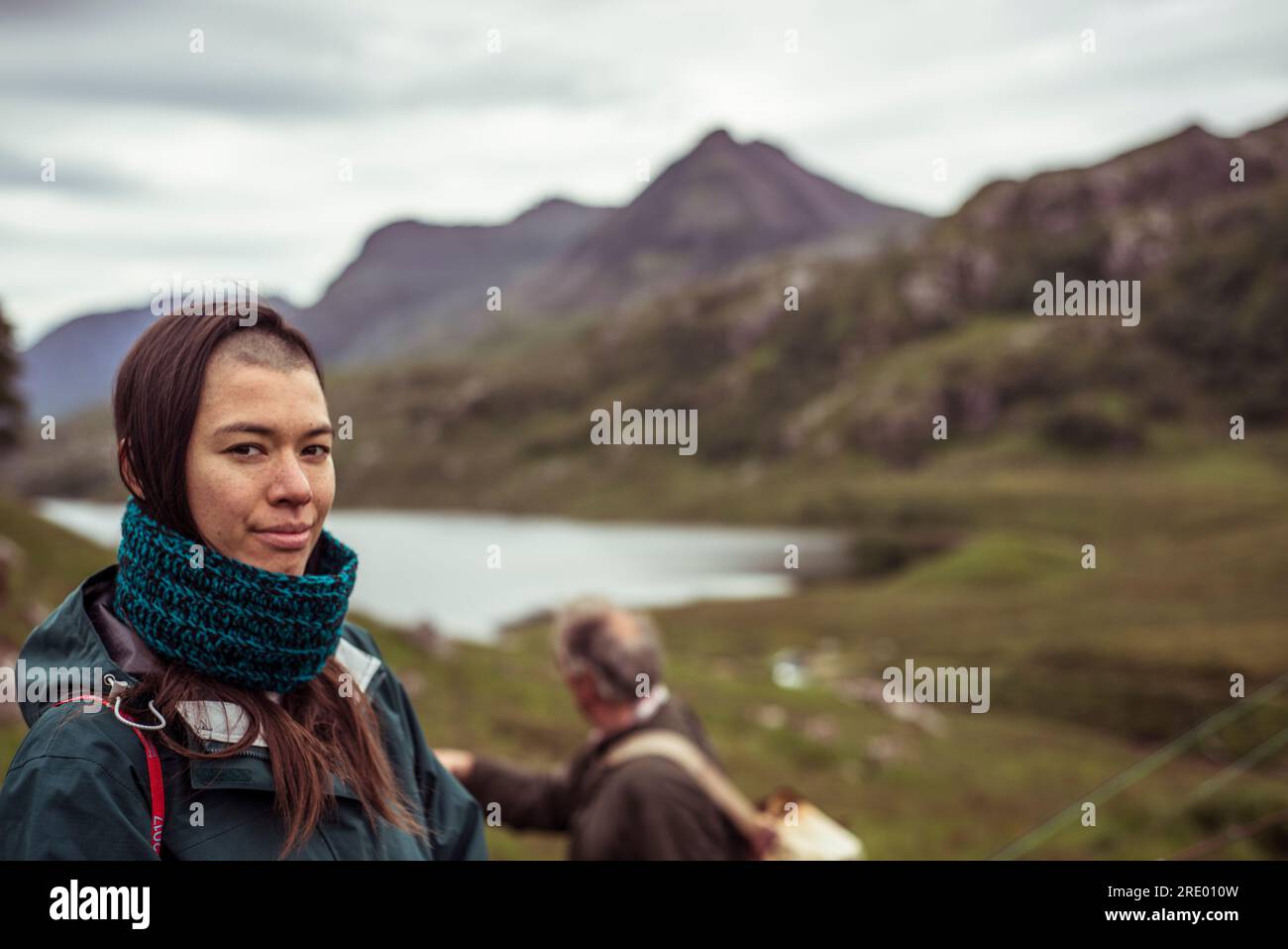 Giovane donna che cammina e pesca con la famiglia nelle Highlands scozzesi Foto Stock