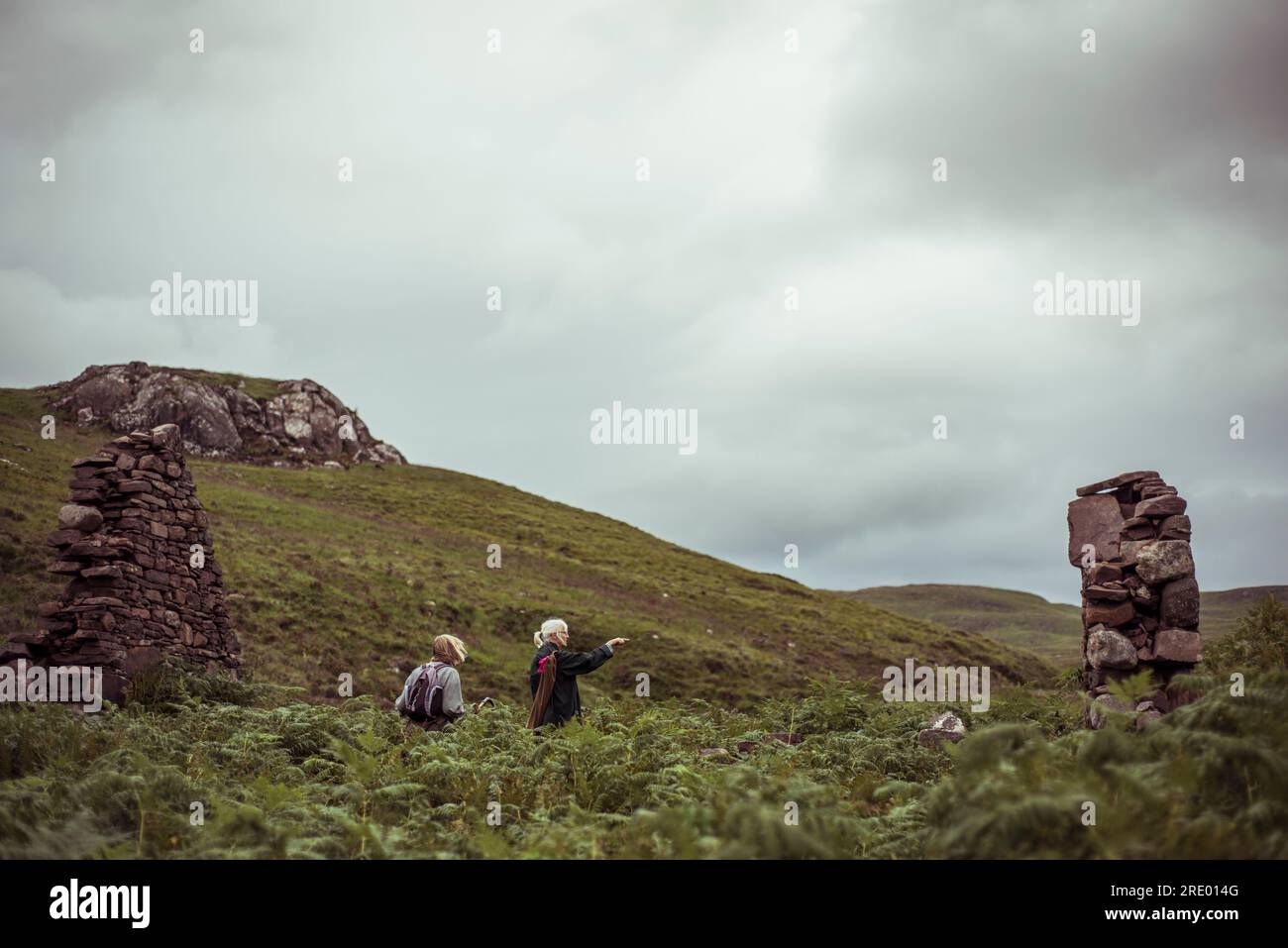 due donne puntano alle rovine nelle selvagge highlands scozzesi Foto Stock