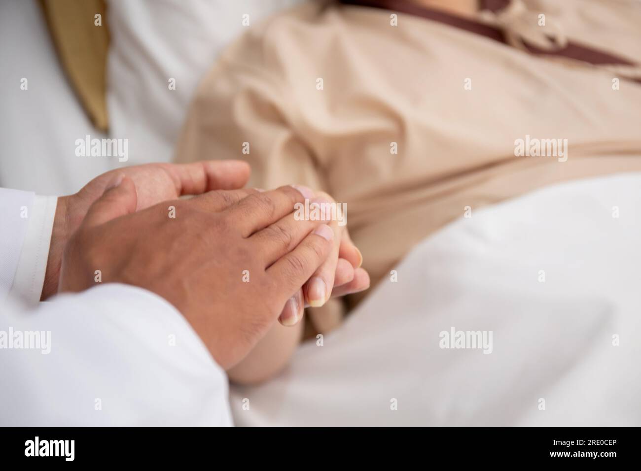Closeup mani di medico uomo incoraggiare con paziente anziano presso l'ospedale, medico prendersi cura e tenersi per mano per consolare anziani malati, diagnosti Foto Stock