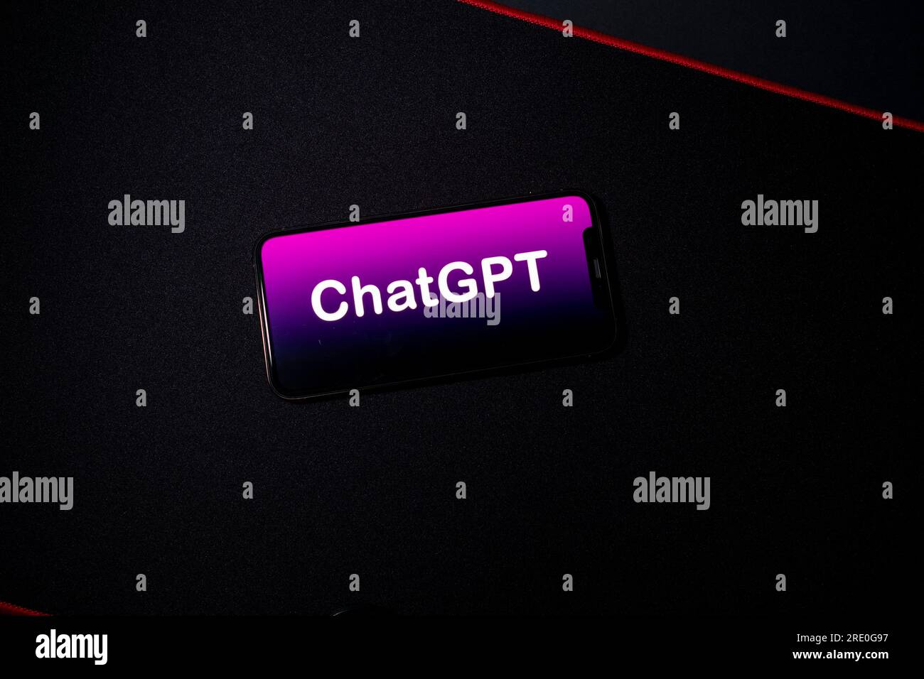 Azzorre, Portogallo - 21.01.2023: Smartphone in cima al pad di gioco da tavolo scuro con logo OpenAI. Vista dall'alto. Sviluppato da OpenAI. Foto Stock