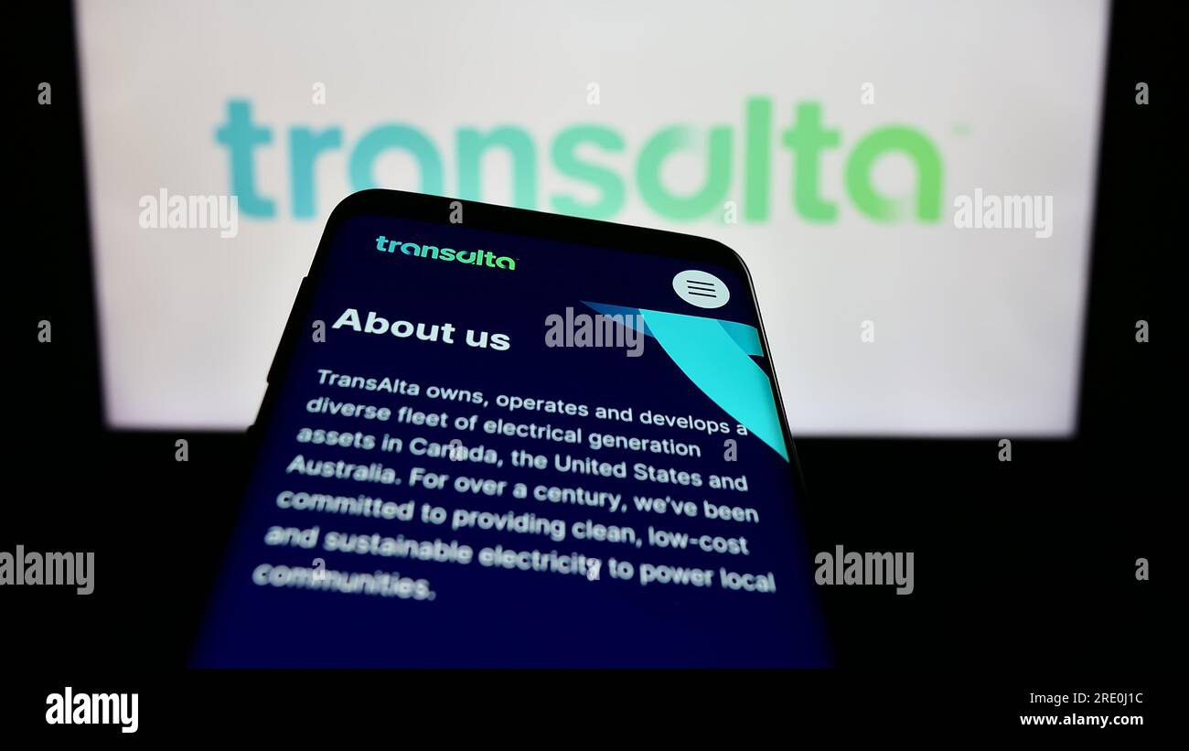 Telefono cellulare con pagina Web della società canadese di energia TransAlta Corporation sullo schermo davanti al logo. Mettere a fuoco in alto a sinistra sul display del telefono. Foto Stock
