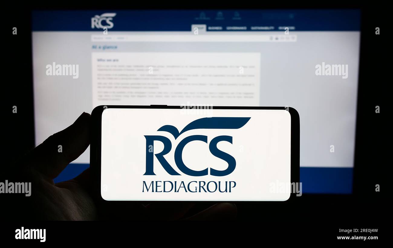 Persona che possiede uno smartphone con il logo della media Company italiana RCS MediaGroup S.p.A. sullo schermo di fronte al sito web. Concentrarsi sul display del telefono. Foto Stock