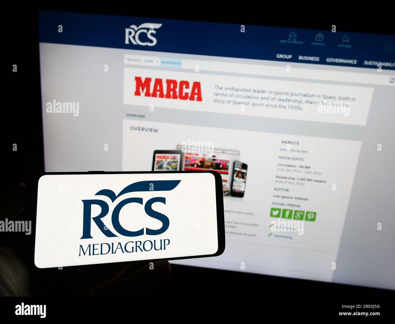 Persona in possesso di cellulare con logo della società italiana di media RCS MediaGroup S.p.A. sullo schermo davanti alla pagina web. Concentrarsi sul display del telefono. Foto Stock
