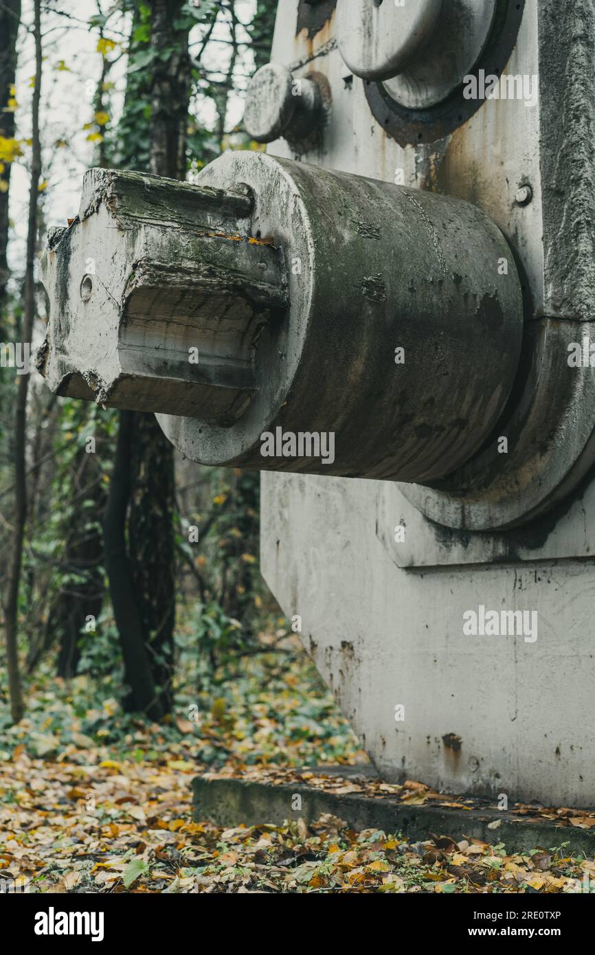 Dettaglio di una vecchia ed enorme macchina per la macinazione dei minerali nella foresta. Macchine abbandonate di storia industriale. Produzione di ferro e acciaio. Foto Stock