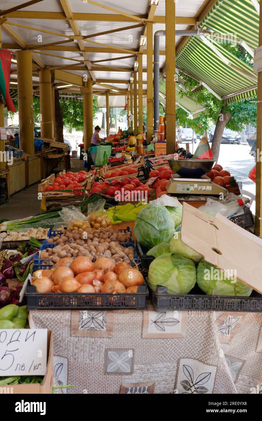 Mercato ortofrutticolo all'aperto coperto a Plovdiv, Bulgaria. Cipolle, noci e cavoli, tra gli altri, e bilance. Foto Stock