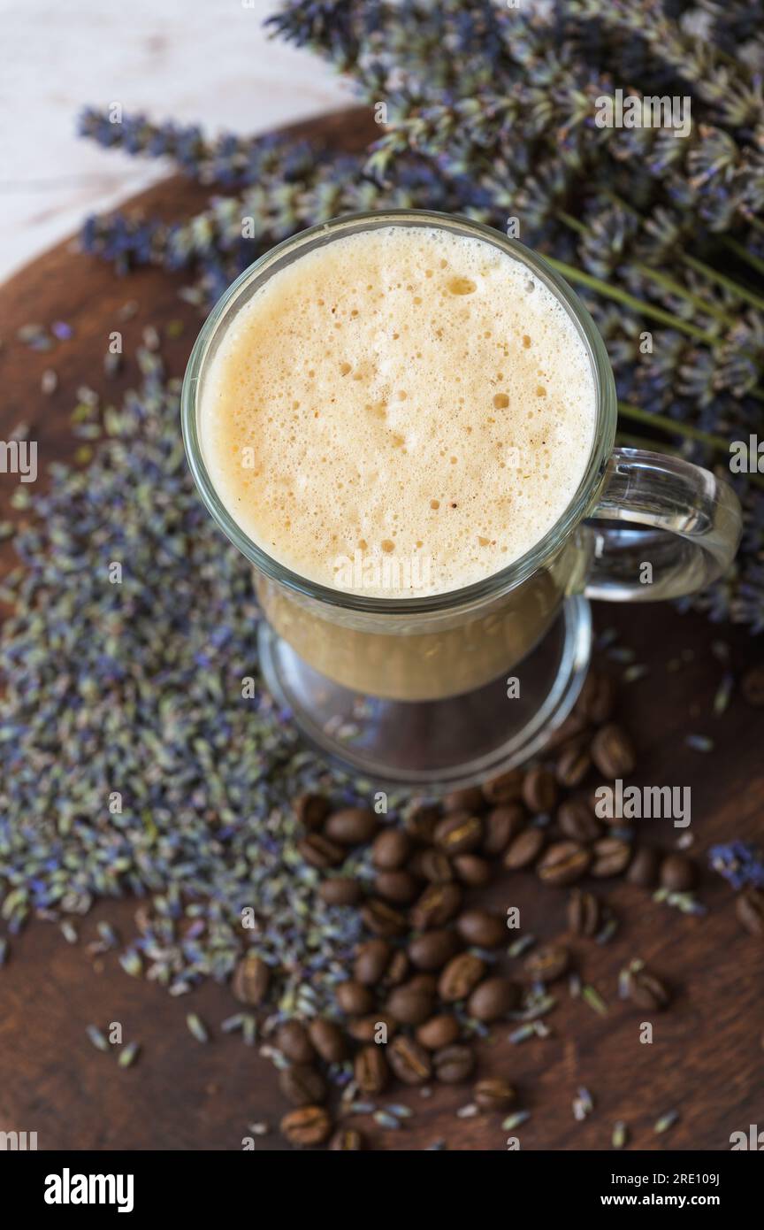 Caffè raf alla lavanda su un asse di legno con lavanda secca e chicchi di caffè. Foto Stock