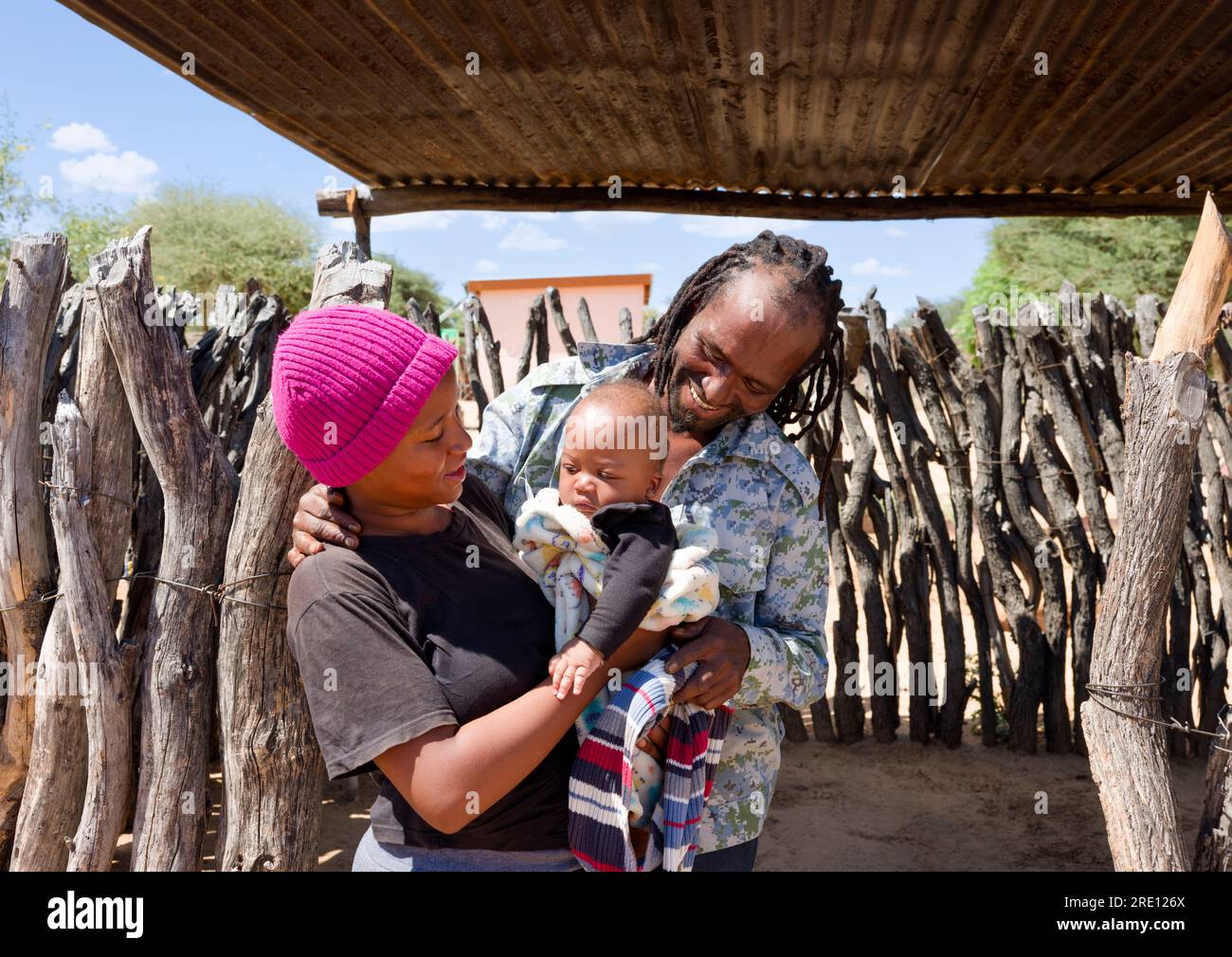 Famiglia africana del villaggio, uomo rastafariano con la moglie che tiene il bambino in giardino Foto Stock