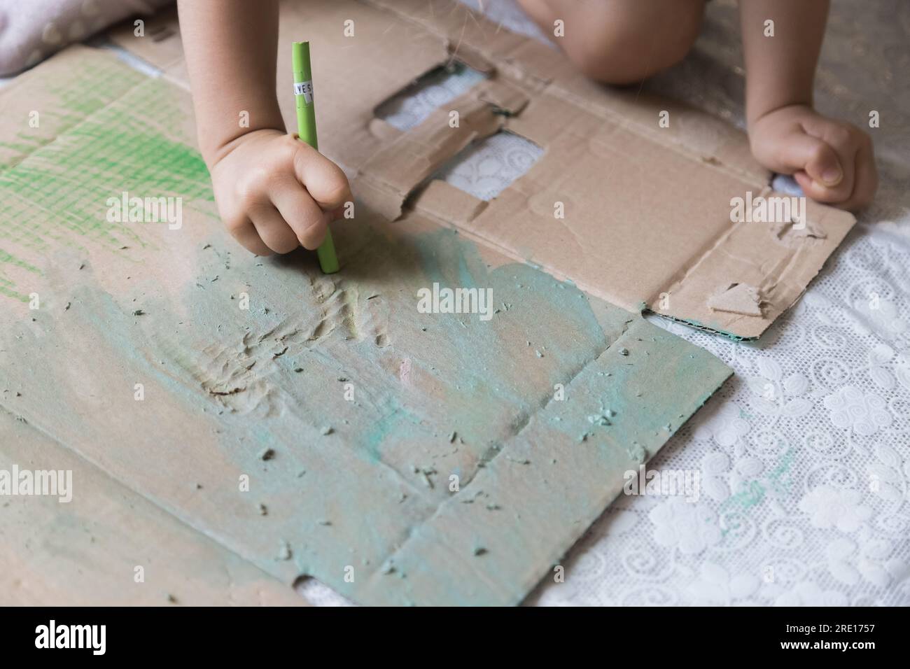 Dolce bambina che gioca con le pitture. Bambino che esplora la sua creatività disegnando sul pavimento della sua casa. Foto Stock
