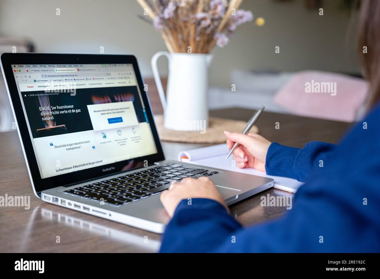 Donna che legge elettricità e gas offre sul sito web di un fornitore di energia. Sullo schermo, il sito Web e lo slogan di Engie: Il principale fornitore di e verdi Foto Stock