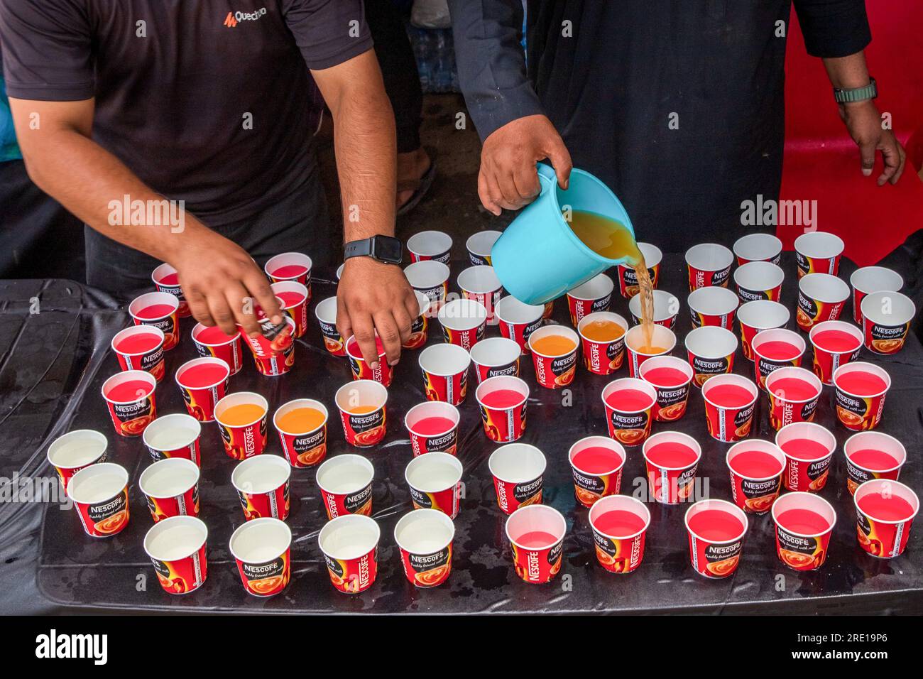 Srinagar, India. 23 luglio 2023. Uomini musulmani sciiti del Kashmir riempiono i bicchieri con acqua potabile ai pendolari in ricordo dei martiri di Karbala durante il mese Muharram. Come Muharram iniziò, come altre parti del mondo, i musulmani sciiti attraverso la valle del Kashmir si stanno preparando per commemorare il martirio dell'Imam Hussain, nipote del profeta Maometto, e dei suoi 72 compagni che furono massacrati a Karbala nel sud dell'Iraq nel 680 d.C. (Foto di Faisal Bashir/SOPA Images/Sipa USA) credito: SIPA USA/Alamy Live News Foto Stock