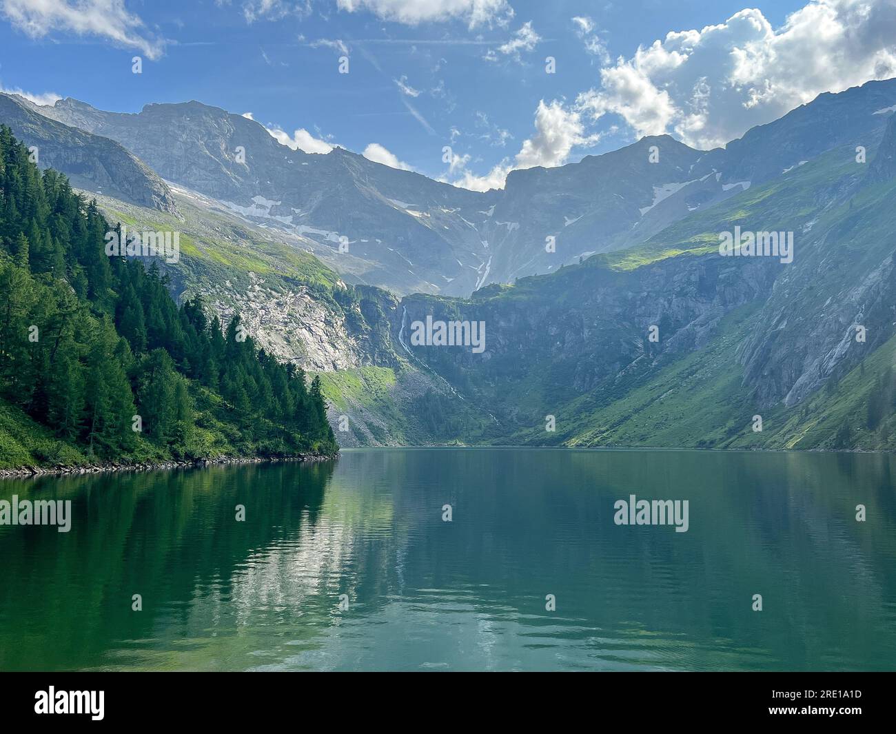 Paesaggio estivo con montagne foreste e cielo nuvoloso nelle Alpi. Austria. Bellezza e tranquillità nell'agricoltura. Vita naturale e sana in un villaggio. Foto Stock