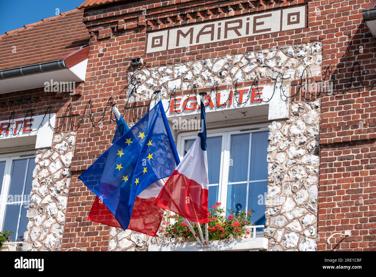 Facciata di un Municipio con una bandiera francese blu, bianca e rossa e una bandiera europea in occasione della Festa Nazionale del 14 luglio. Motto in prima linea Foto Stock