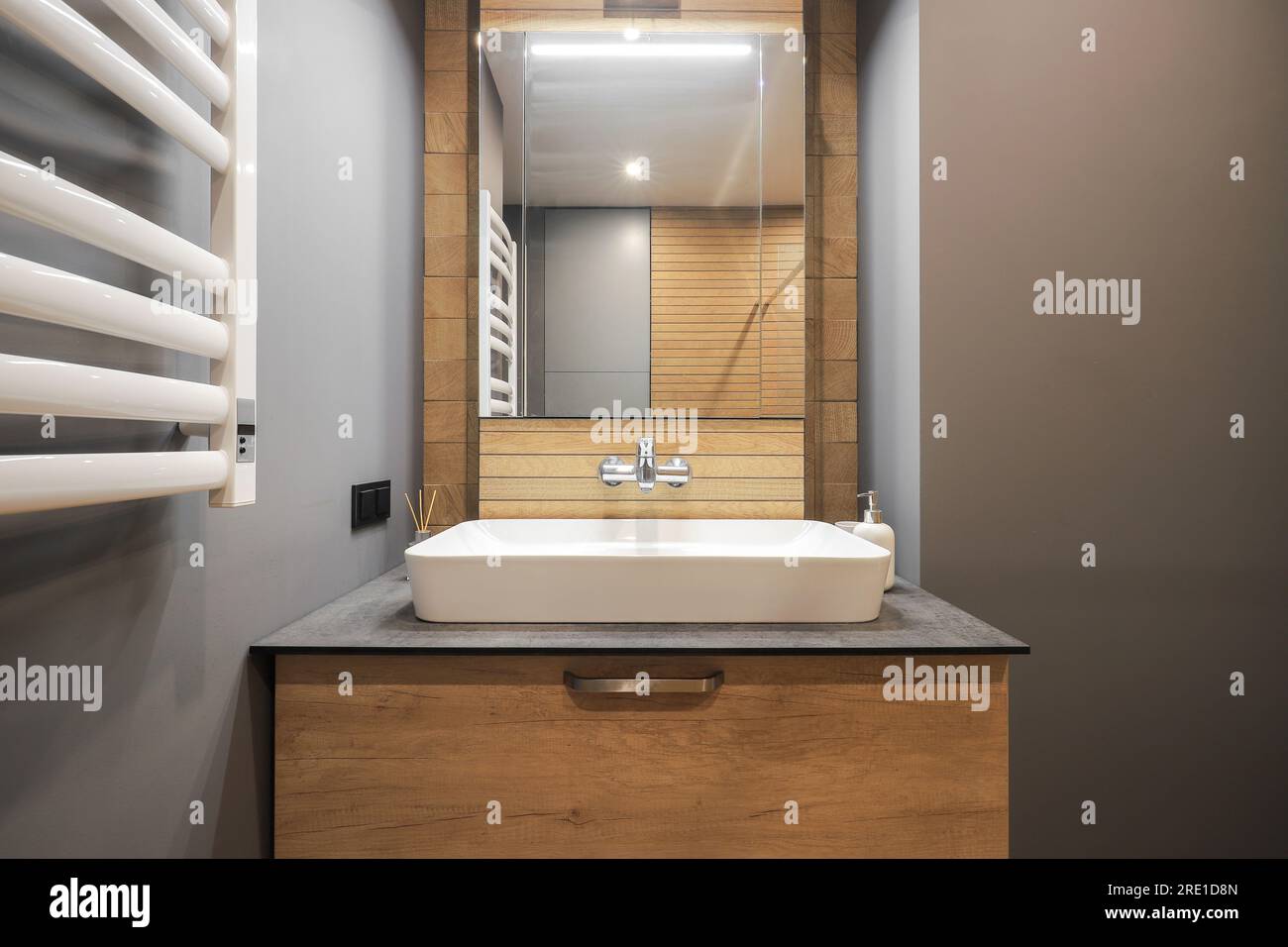 Rubinetto con lavabo in ceramica e specchio all'interno del bagno Foto Stock Rubinetto con lavabo in ceramica e specchio all'interno del bagno Foto Stock