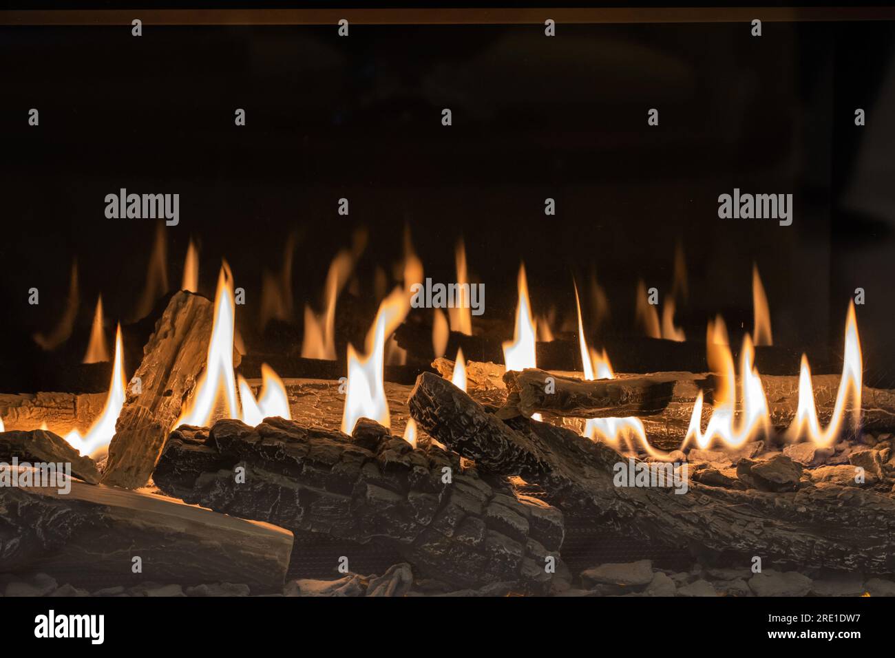 Caminetto a gas con vista ravvicinata sulla legna da ardere Foto Stock