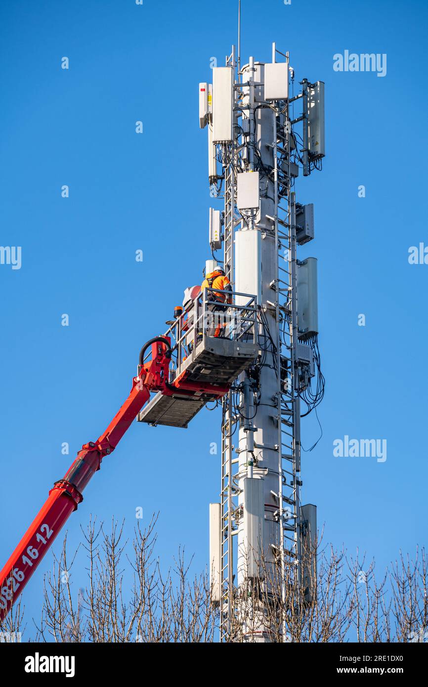 Implementazione del 5G in Francia: Installazione di stazioni di trasmissione per telefoni cellulari con piattaforma di lavoro aerea. Tecnici al lavoro. Telefono francese e Internet pro Foto Stock