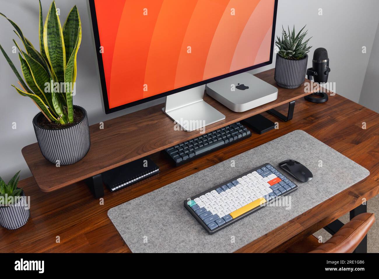 LONDRA - 12 LUGLIO 2023: Apple Studio display e Mac Mini computer in un moderno ufficio domestico, lavoro da casa configurazione minima della scrivania Foto Stock