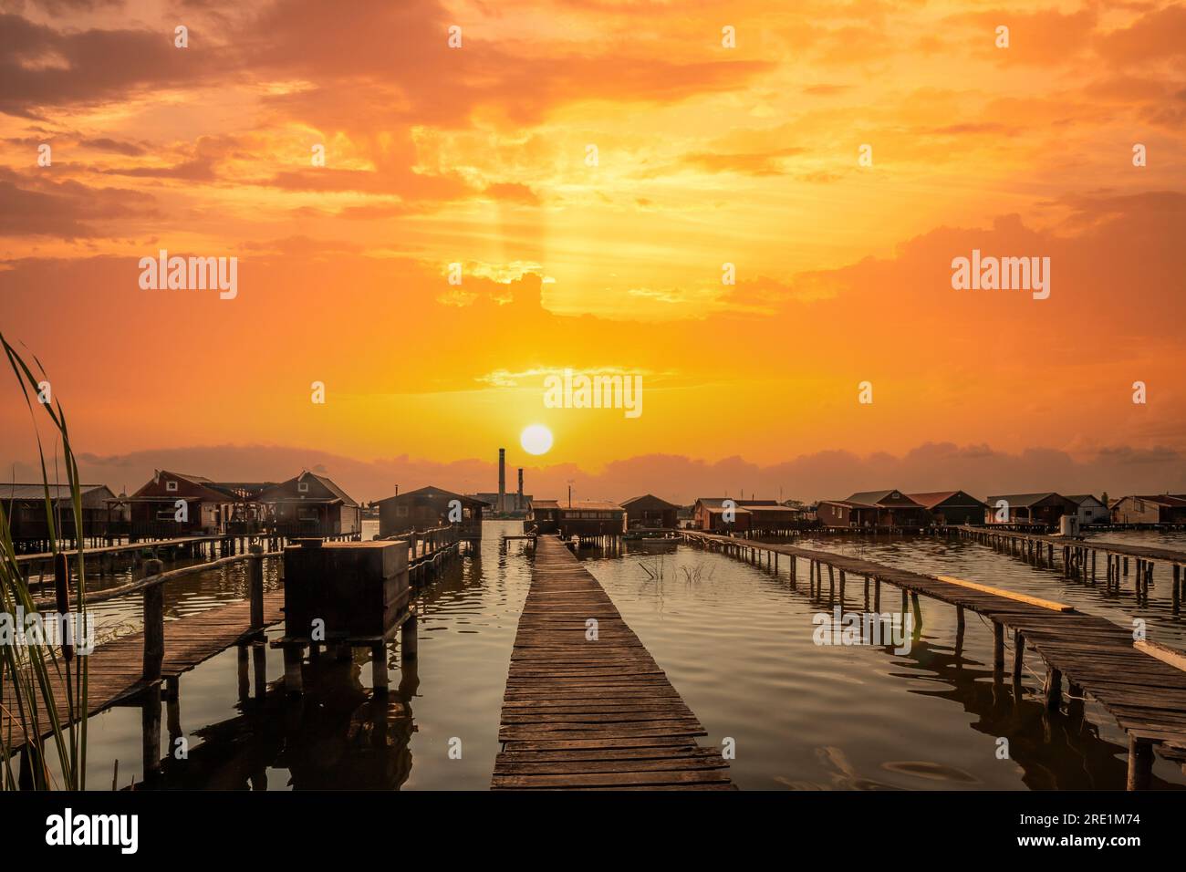 Case di pesca, casa per le vacanze, casa di legno nel lago con molo. Bokod Ungheria Bora Bora paesaggio con tramonto Foto Stock