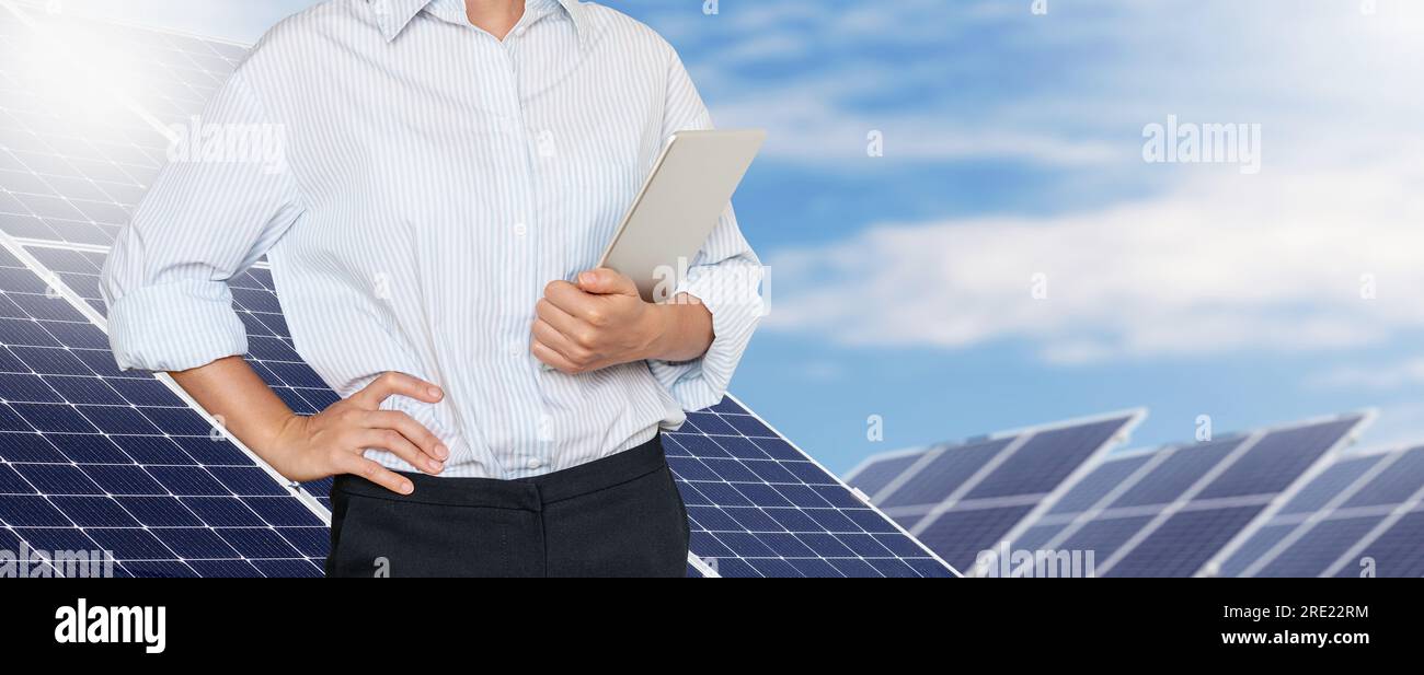 Ingegnere donna in piedi sullo sfondo di pannelli di energia solare in una fattoria solare Foto Stock