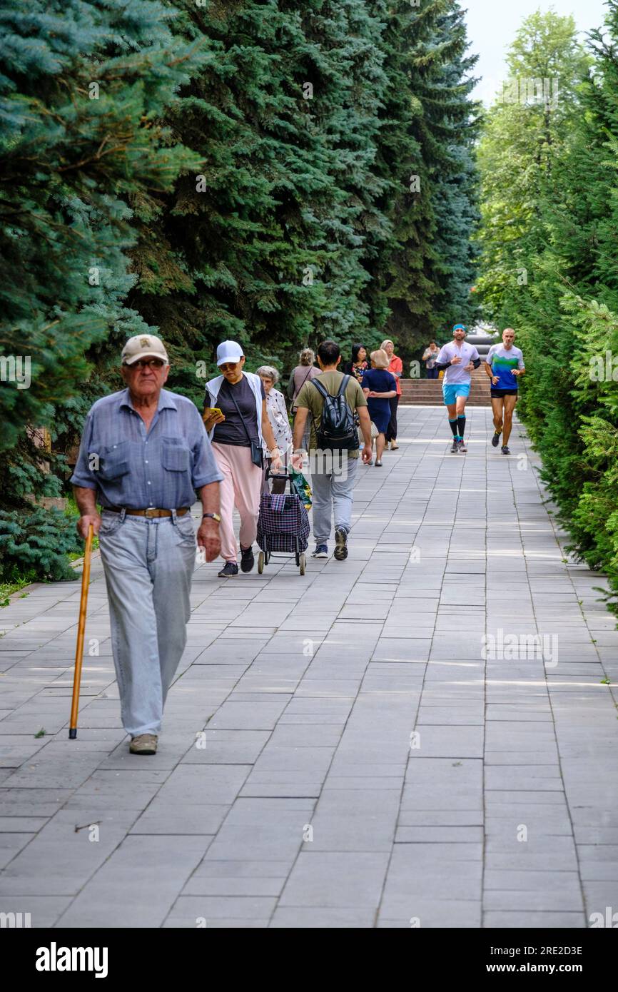 Kazakistan, Almaty. People Walking, jogging, nel Panfilov Guardsmen Park. Foto Stock